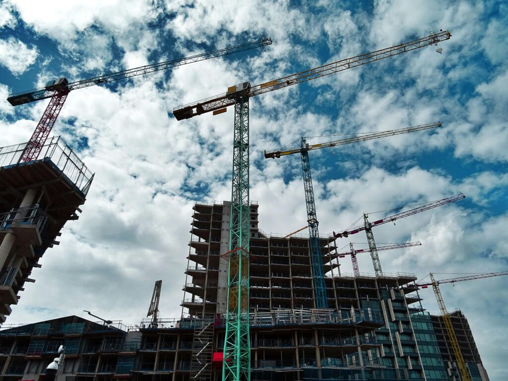 pexels-photo-439416-439416 Urban construction site with numerous cranes framing rising skyscrapers against a blue sky.
