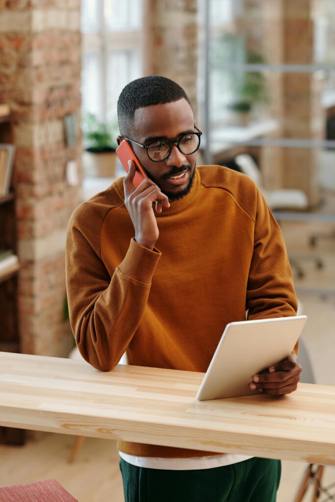 pexels-photo-6149791-6149791 Young man in a modern office multitasking with a digital tablet and mobile phone.